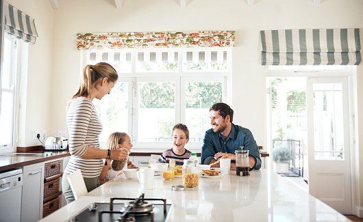 Shot of a happy family of four having breakfast together in the kitchen at home